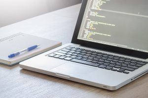 laptop with coding on screen TechChaps